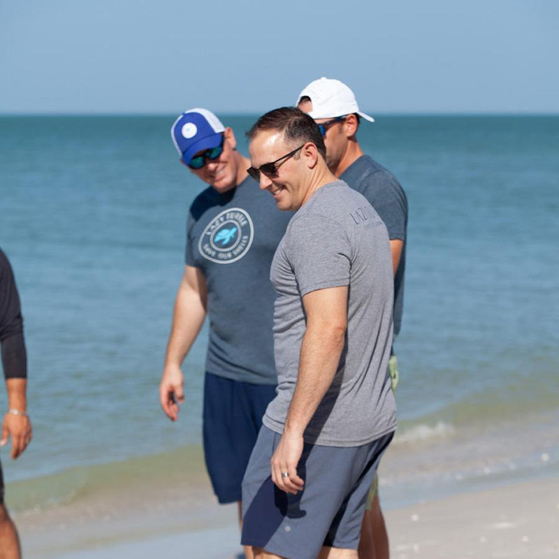 Men on beach wearing Slow Lane Tee